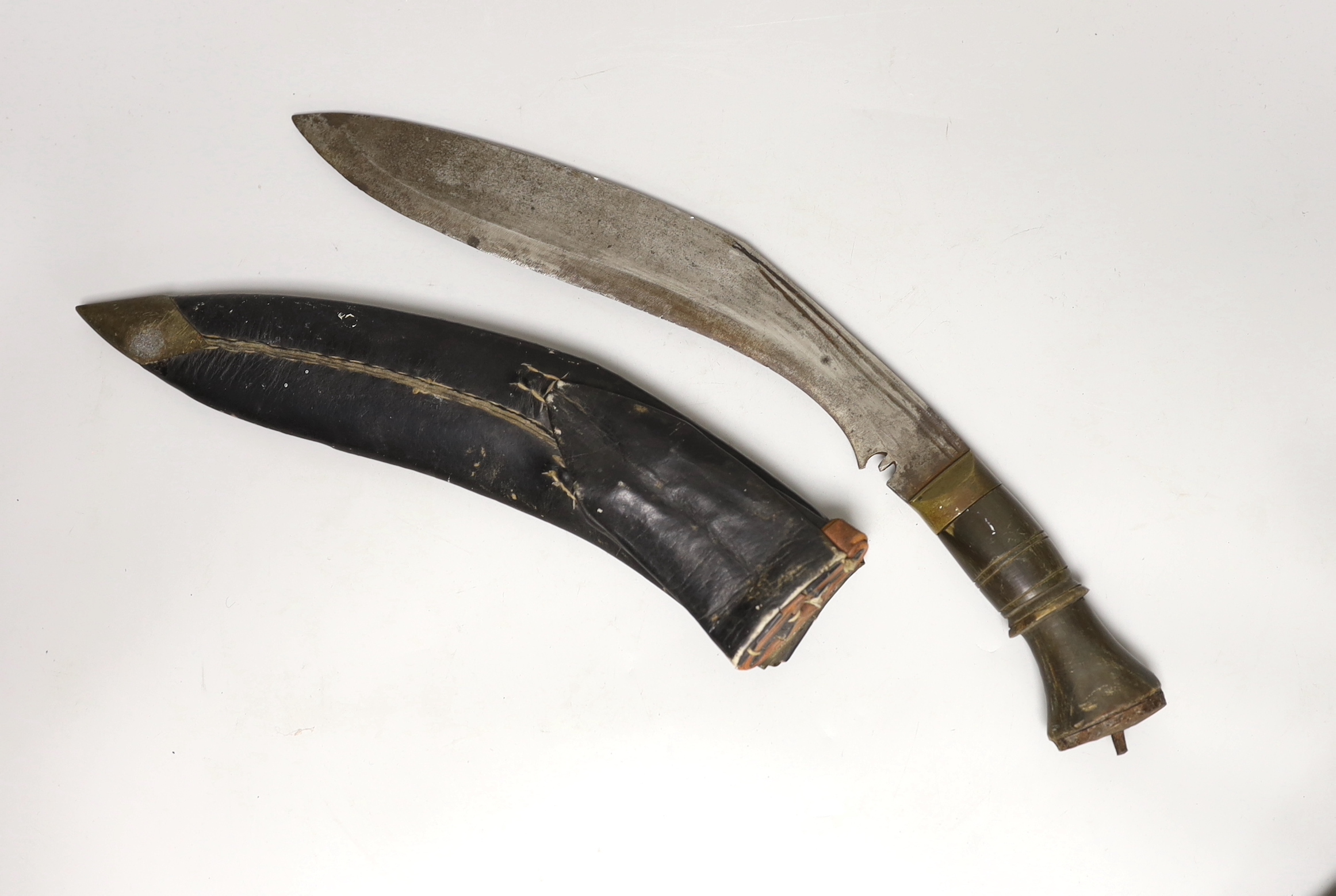 A kukri within white metal mounted sheath, blade 27cm, and three others, one with bone handle